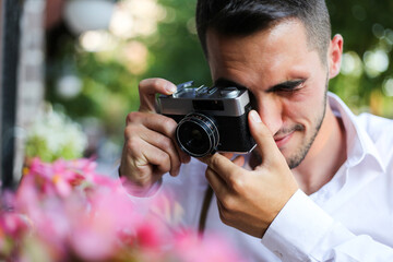 a young man takes photos in the city with his antique photo camera