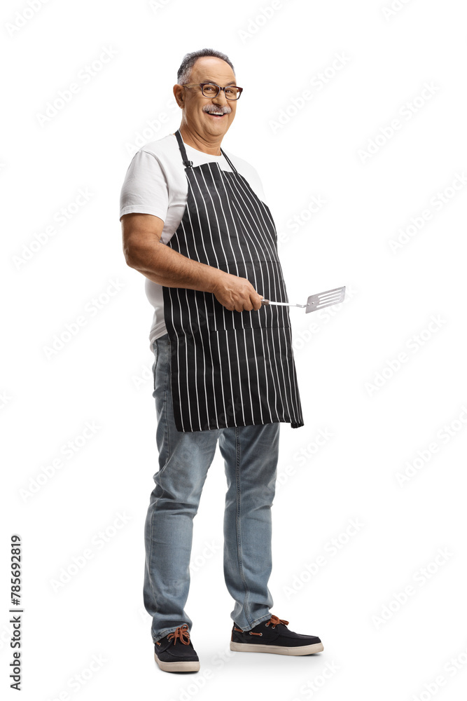 Poster Mature man wearing an apron and holding a turner utensil