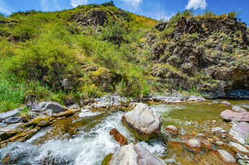 Fototapeta na wymiar Experience the serenity of nature's beauty. Watch the river meander through the rocky canyon. Feel the majestic power of the mountains surrounding you.