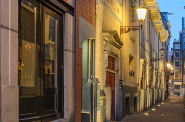 A narrow street with streetlights in Amsterdam.