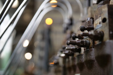 Row of industrial valves with bokeh lights, manufacturing facility and process control concept