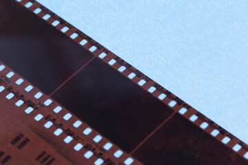 Naklejka premium 35mm positive filmstrips with empty frames, real scan of film material with cool scanning light interferences on the material. 