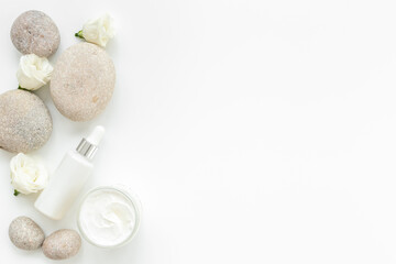 Obraz na płótnie Canvas Blank white bottles of skin care cosmetics with roses