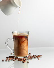 Coffee with cream on a glass table. - 785702647
