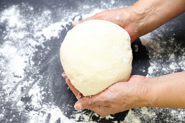 Woman's hands knead the dough for baking bread. The chef. Close-up of woman's hands kneading dough