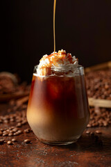 Iced caramel latte topped with whipped cream and caramel sauce. - 785702677