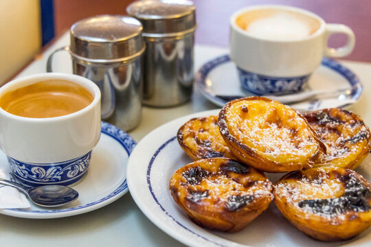 Pasteles de Bel&eacute;m y tazas de caf&eacute; con leche