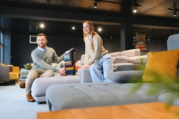 Couple choosing sofa in furniture store