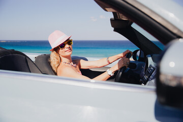 Happy woman travels by car on summer vacation