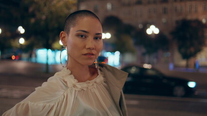 Night girl standing street near road traffic closeup. Gorgeous short hair model 