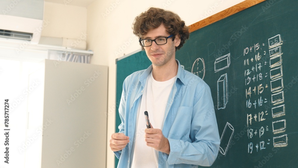 Poster caucasian teacher looking at student while standing at blackboard. low angle camera of professional 