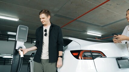 Electric car driver checks battery charging status, range and charging limit on app screen in the...