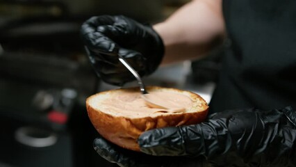 Chef Spreading Sauce On The Bread Bun With Spoon