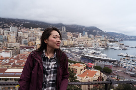 Young woman overlooking Monaco cityscape and harbor