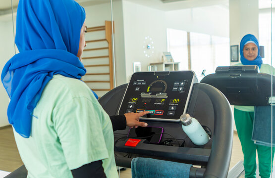 Arabian woman using treadmill at modern gym
