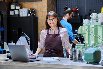 Colleagues, partners, man and woman behind counter in coffee shop