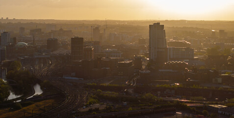 A serene cityscape of Leeds at sunrise, with the emerging daylight piercing through the morning...
