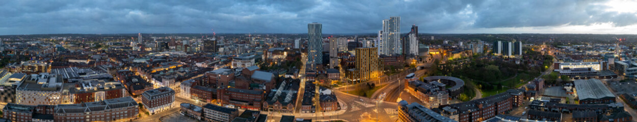Early morning sunrise touches the Leeds, West Yorkshire cityscape, featuring the city centre and building construction, captured aerially by a drone
