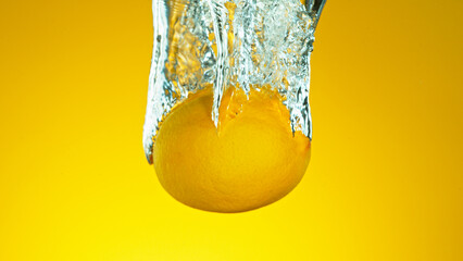Freeze motion of falling fresh lemon fruit into water