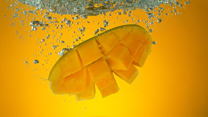 Freeze motion of falling fresh mango fruit into water - obrazy, fototapety, plakaty