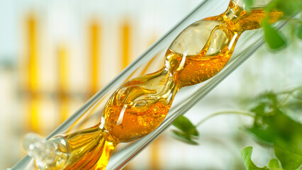 Getting essential oil from natural substances and flowers. Yellow oil flows in a spiral.