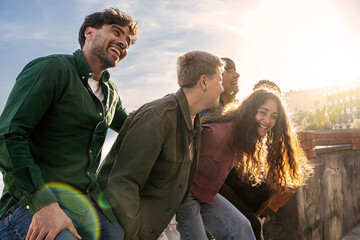 A group of friends share contagious laughter in a sunlit setting - companionship joy and casual...