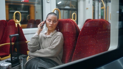 Tired tourist calling mobile phone in train. Short hair woman talking smartphone - obrazy, fototapety, plakaty