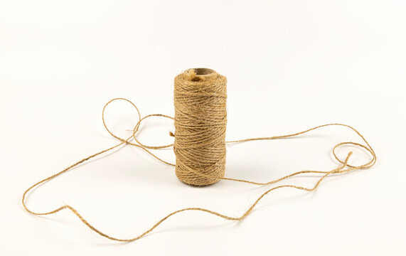 A spool of linen rope on a white background. The concept of textiles and sewing.