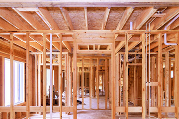 View inside new house under construction showing incomplete wooden home framing beams