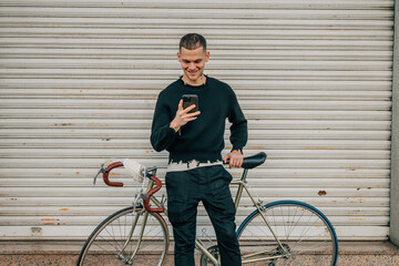 portrait young man on the street with smartphone or cell phone and bicycle