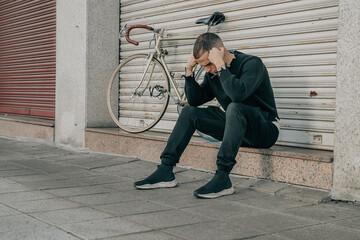 young man sitting on the street with problem expression
