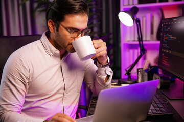 Smart IT developer drinking coffee cup while working in software development coding on pc screen,...