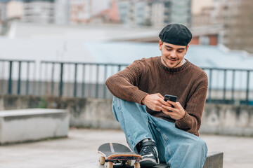 young man on the street with mobile phone and skateboard - 785745065