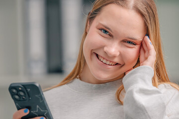 smiling young girl or woman at home with mobile phone