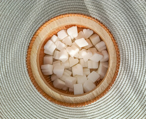 Fototapeta na wymiar Heart shaped sugar cubes in a wooden container, top view 