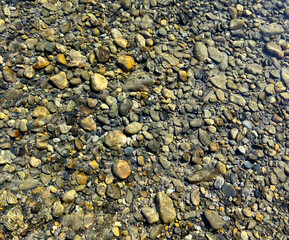 Filled background of river stones under clear water