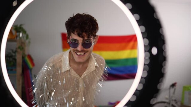 view through a ring light of a man dancing looking at camera while celebrating gay pride freedom party