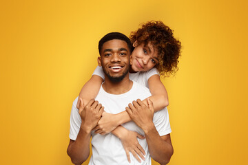 Cute african-american girl embracing her boyfriend from back