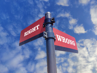Right vs wrong. White two street signs with arrow on metal pole with word. Directional road. Crossroads Road Sign, Two Arrow. Blue sky background. Two way road sign with text.