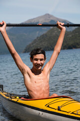 Very happy teenager kayaking and enjoying the summer during his school holidays in Bariloche, Patagonia, Argentina.
