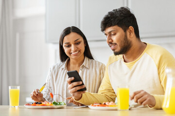 Couple with smartphone sharing a moment during breakfast