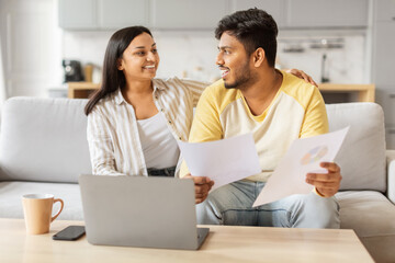 Relaxed couple discussing with laptop at home