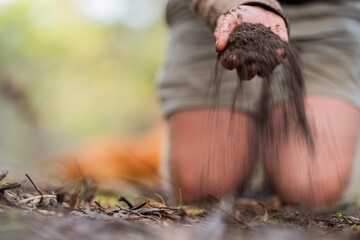 farmer hold soil in hands monitoring soil health on a farm.