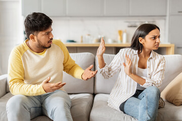 Couple arguing on sofa in living room