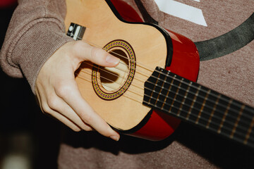 A teenage girl plays the guitar.
