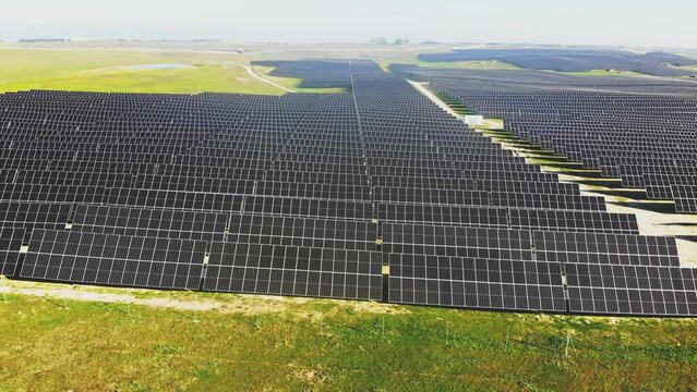 Aerial 4K video of photovoltaic solar power plant in motion, sweeping the image from the right side to the left