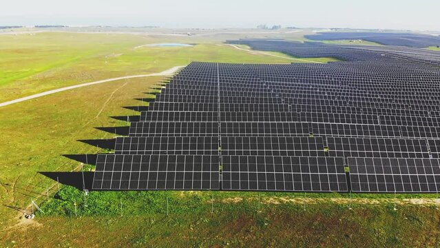 Aerial 4K video of photovoltaic solar power plant in motion, sweeping the image from the right side to the left