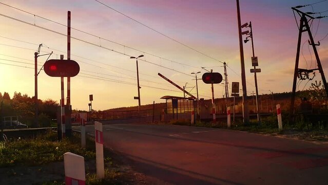 Guarded railroad crossing gate closing before local train passing