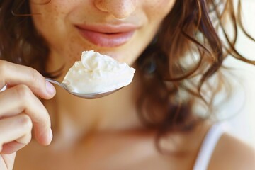 High-definition close-up of a woman enjoying a spoonful of yogurt