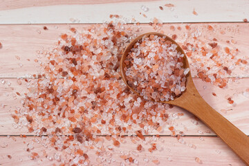 Top view of Himalayan pink salt on a wooden spoon.